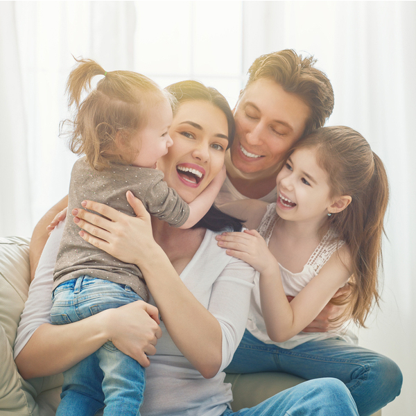 Family of Four Laughing On Couch